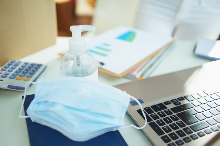 Administrative desk with a mask and hand sanitizer. Administrative services desk.